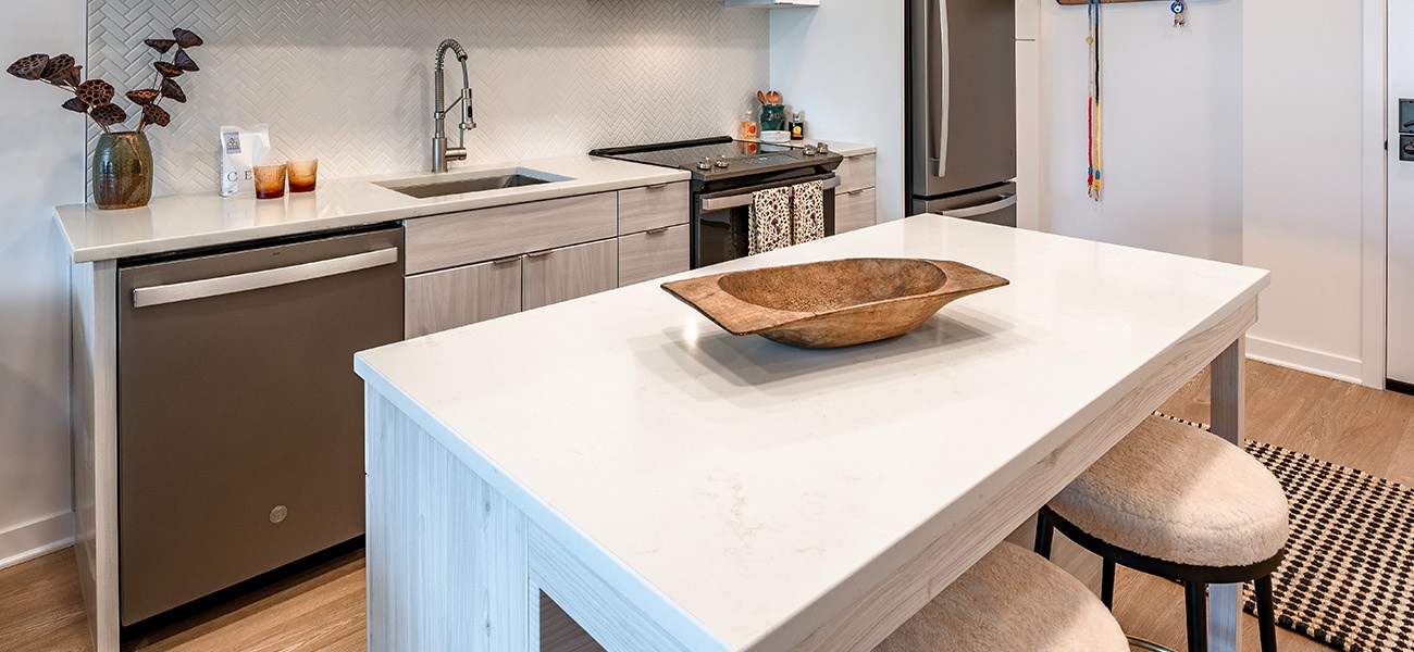 Spacious and well lit kitchen with wood floors and stainless steel appliances